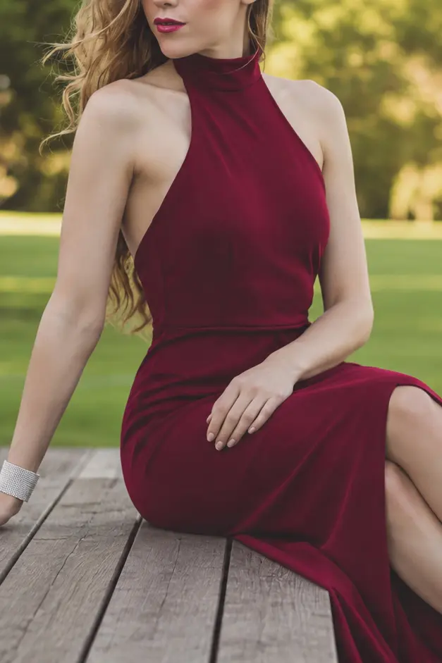 The Hague escorts: elegant escort in a burgundy halter gown seated by the pool