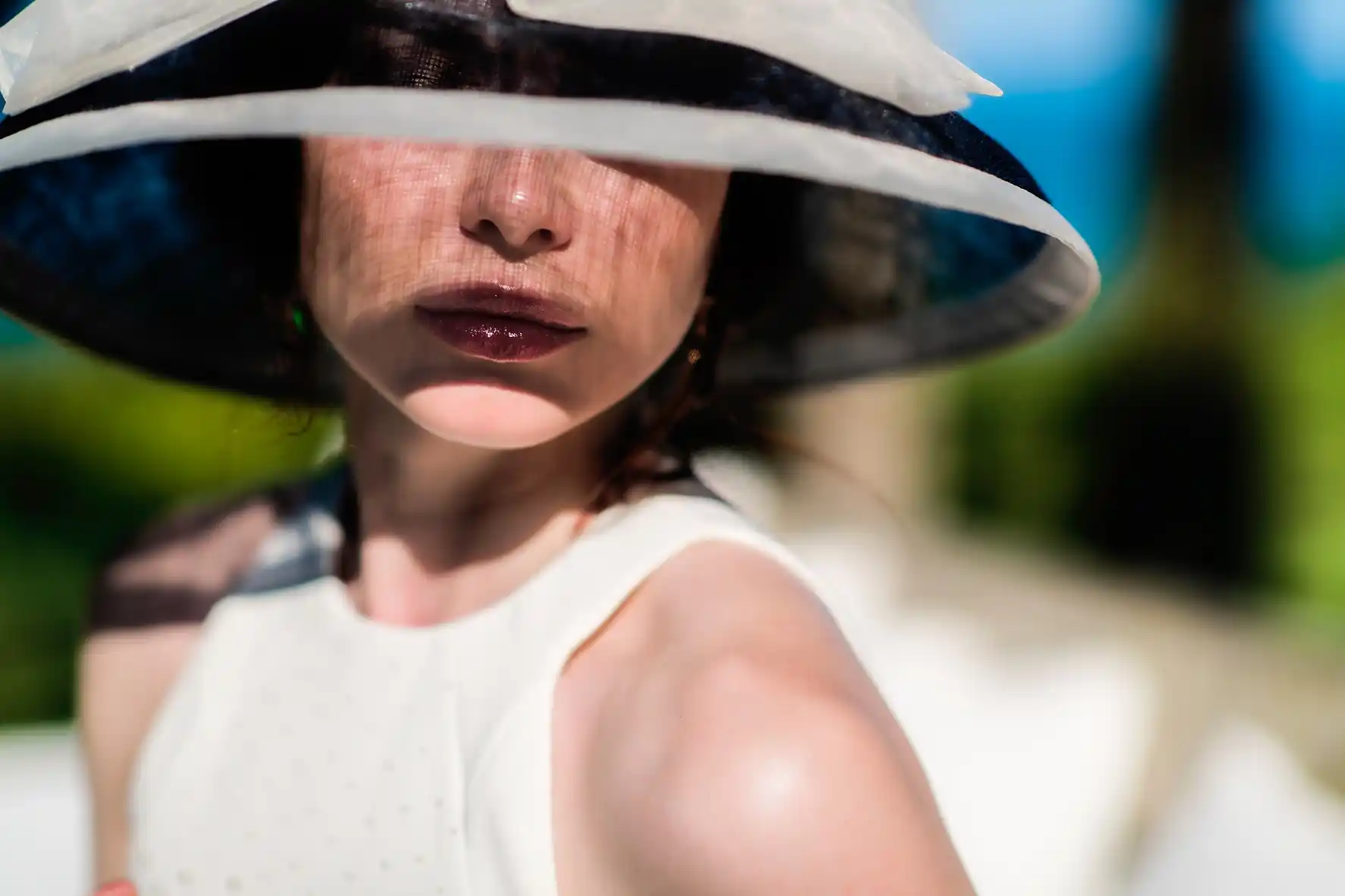 High-class escort Schiphol: elegant escort in a wide-brimmed sun hat and white dress